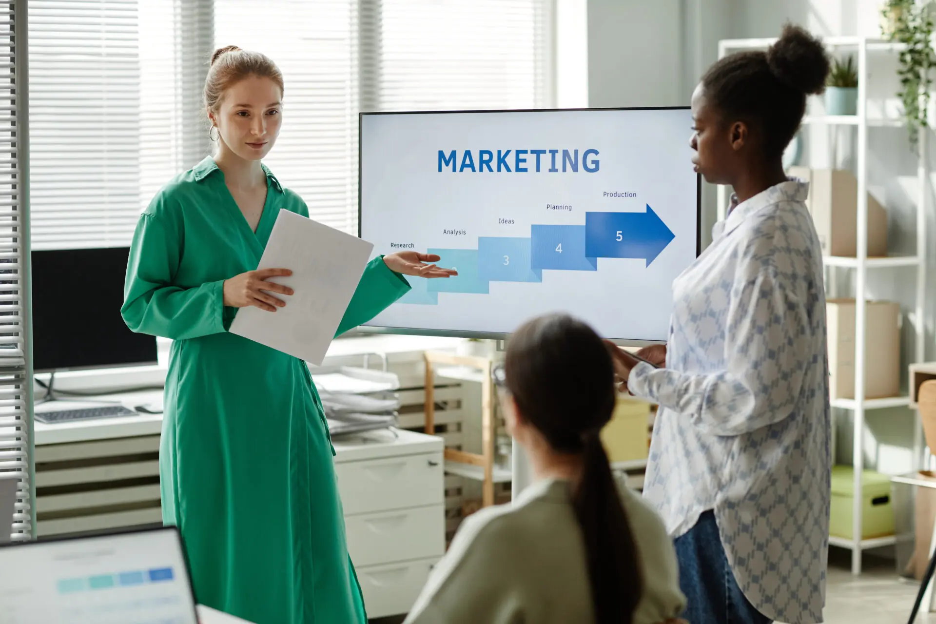 Nashville businesswoman with marketing plan pointing at screen with graphs and giving new information